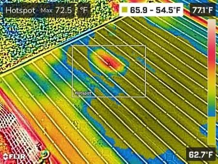 Thermal imaging of a solar PV array showing a hotspot anomaly within a temperature range overlay